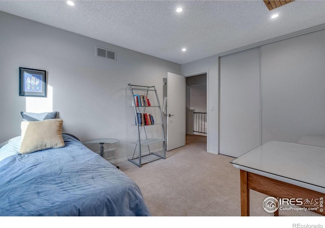 bedroom featuring carpet floors, a textured ceiling, and a closet