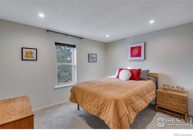 bedroom featuring light colored carpet and a textured ceiling