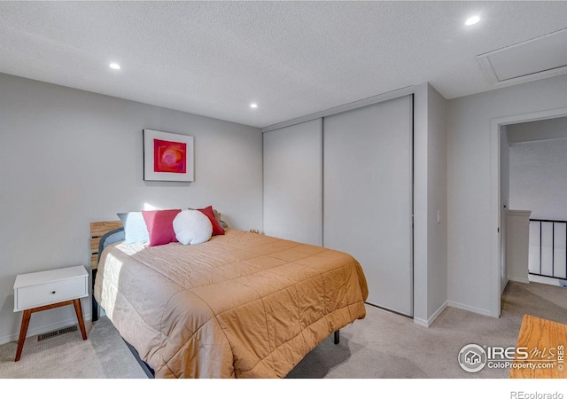 bedroom with light carpet, a closet, and a textured ceiling