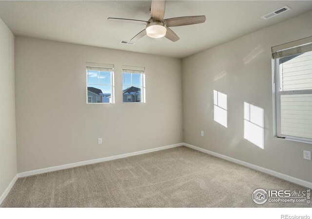 spare room featuring ceiling fan and carpet