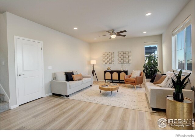 living room featuring ceiling fan and light hardwood / wood-style flooring