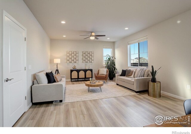 living room featuring light hardwood / wood-style floors and ceiling fan