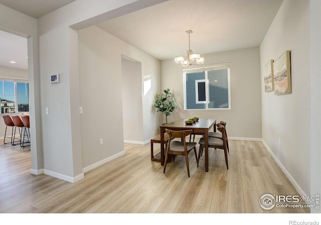 dining space featuring an inviting chandelier and light hardwood / wood-style flooring