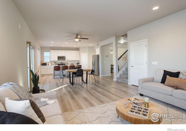 living room with ceiling fan and light hardwood / wood-style floors