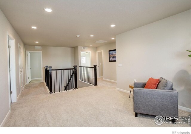 sitting room featuring light colored carpet