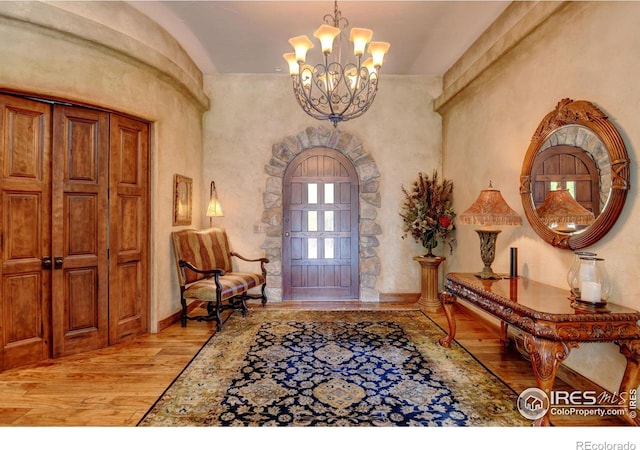 foyer entrance featuring light hardwood / wood-style flooring and an inviting chandelier