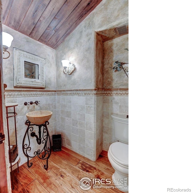 bathroom with toilet, tile walls, and wood ceiling