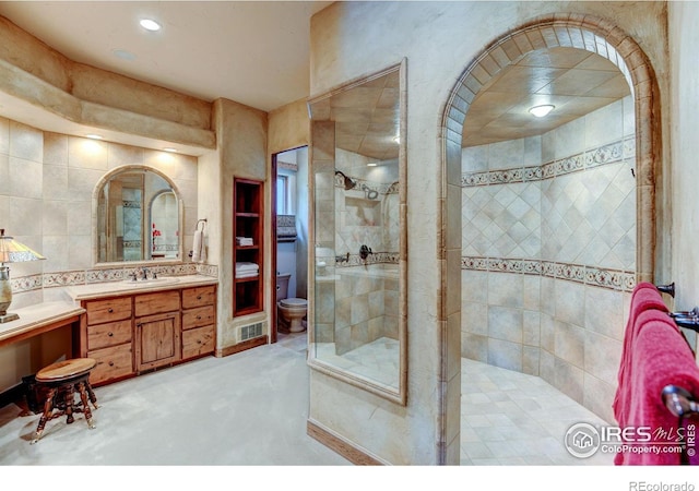 bathroom featuring backsplash, vanity, and tiled shower