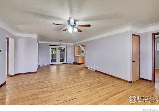 unfurnished living room featuring a textured ceiling, french doors, ceiling fan, and light wood-type flooring