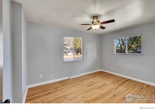 empty room featuring ceiling fan, a baseboard radiator, a healthy amount of sunlight, and light hardwood / wood-style flooring