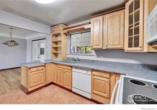 kitchen with white dishwasher, sink, light brown cabinetry, and stove