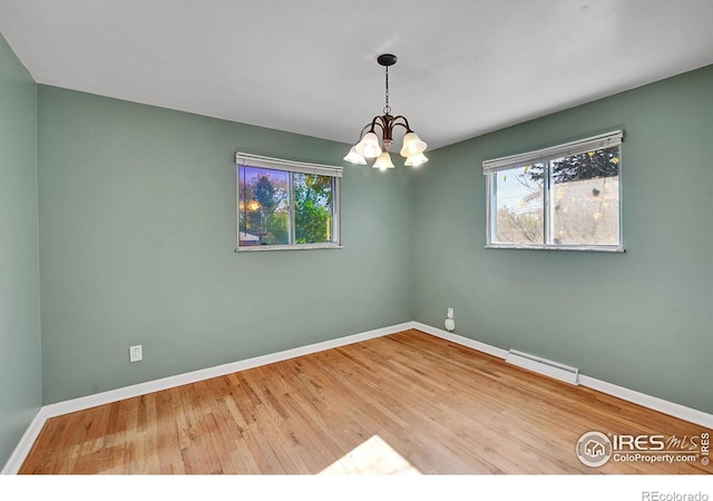 unfurnished room featuring hardwood / wood-style flooring and a chandelier