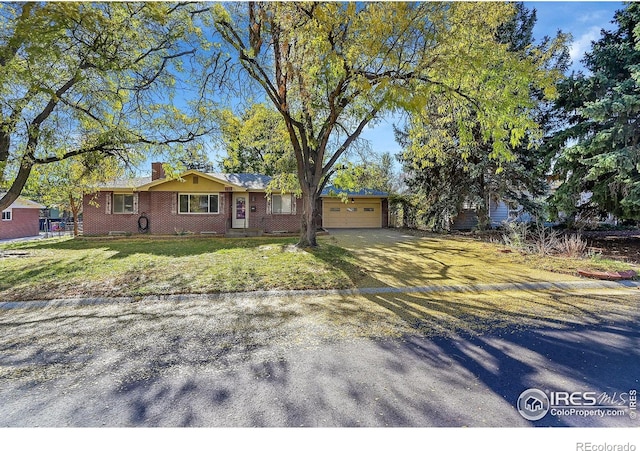 single story home featuring a garage and a front lawn