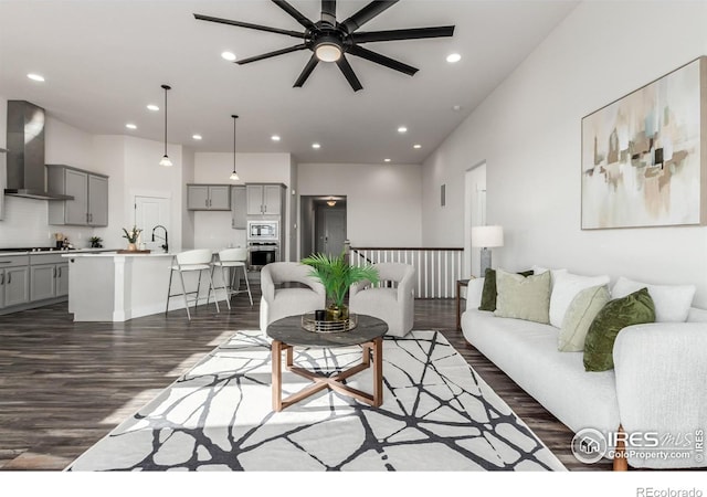 living room featuring dark hardwood / wood-style floors, ceiling fan, and sink