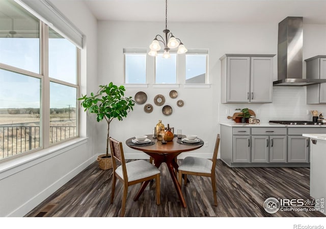 dining space featuring dark wood-type flooring and a notable chandelier