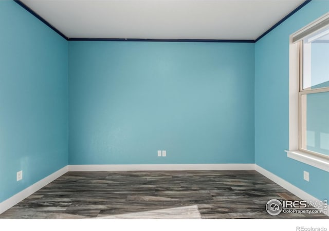 empty room featuring crown molding and dark wood-type flooring