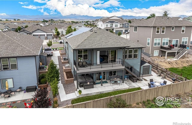 back of house with a mountain view, outdoor lounge area, a patio, and a balcony