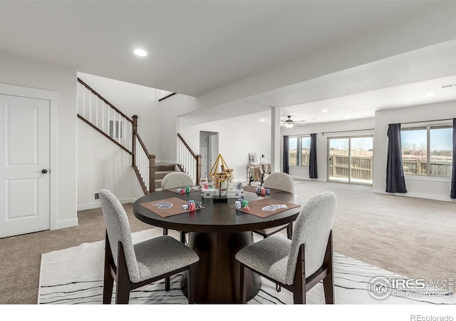 dining space featuring ceiling fan and light carpet