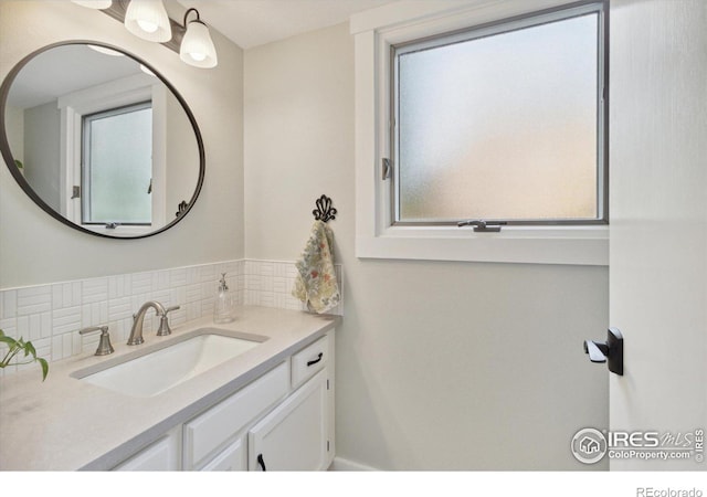 bathroom featuring vanity, tasteful backsplash, and a healthy amount of sunlight