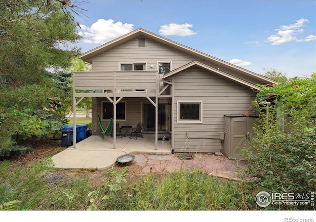 rear view of property with a balcony and a patio area