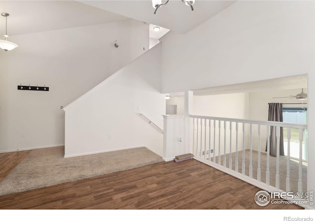 stairway featuring hardwood / wood-style floors and ceiling fan with notable chandelier