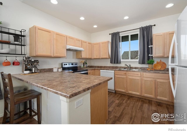 kitchen with kitchen peninsula, light brown cabinetry, white appliances, and sink