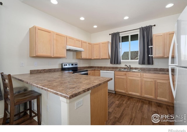 kitchen with white appliances, sink, light brown cabinetry, dark hardwood / wood-style flooring, and kitchen peninsula