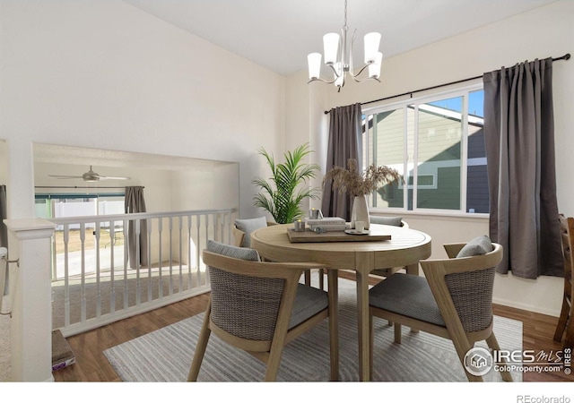 dining area with hardwood / wood-style floors, a healthy amount of sunlight, and ceiling fan with notable chandelier