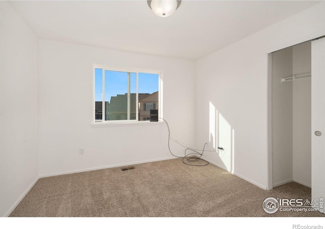 unfurnished bedroom featuring carpet and a closet