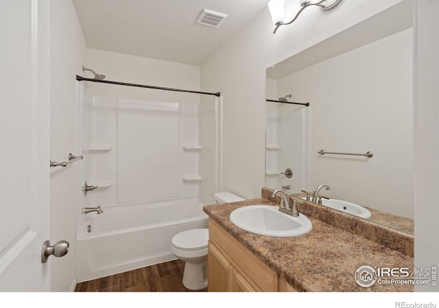 full bathroom featuring hardwood / wood-style floors, vanity, toilet, and shower / tub combination