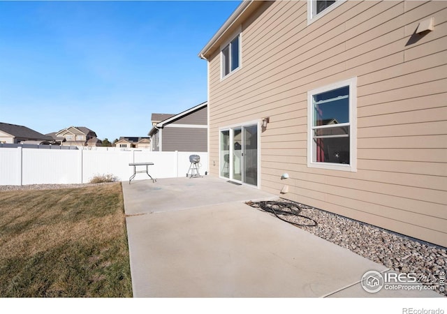 back of house with a patio area and a lawn