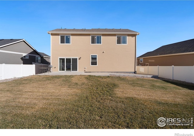 rear view of house featuring a lawn and a patio area