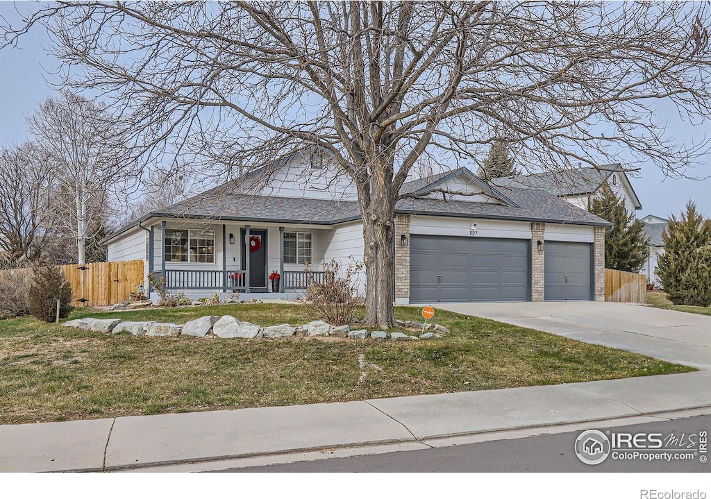 view of front of property with a porch, a garage, and a front yard