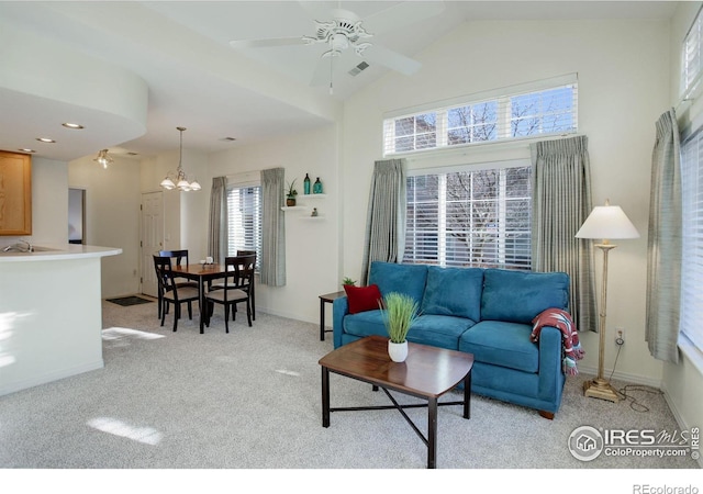 living room with light carpet, ceiling fan with notable chandelier, and lofted ceiling