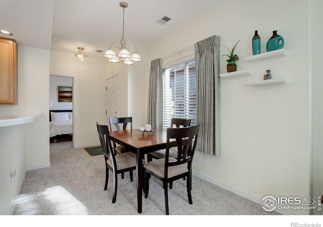 dining space featuring light colored carpet and a notable chandelier