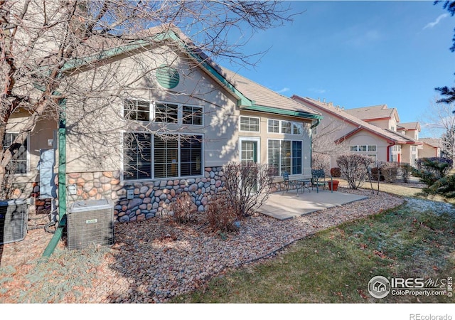 rear view of property with a patio area and central AC