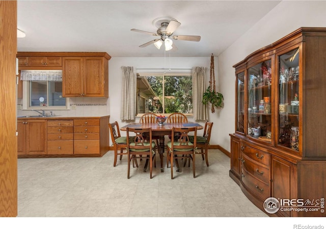 dining room with ceiling fan and sink