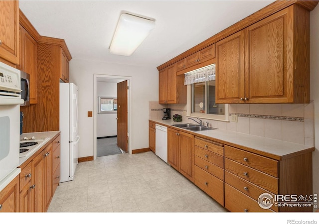 kitchen with white appliances, tasteful backsplash, and sink