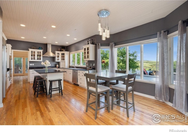 dining area featuring sink, a notable chandelier, and light wood-type flooring