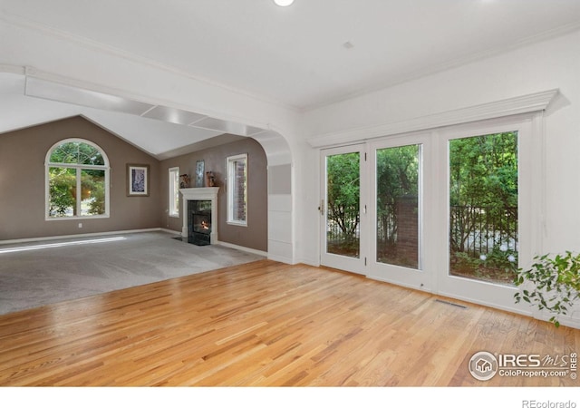 unfurnished living room with light wood-type flooring and vaulted ceiling