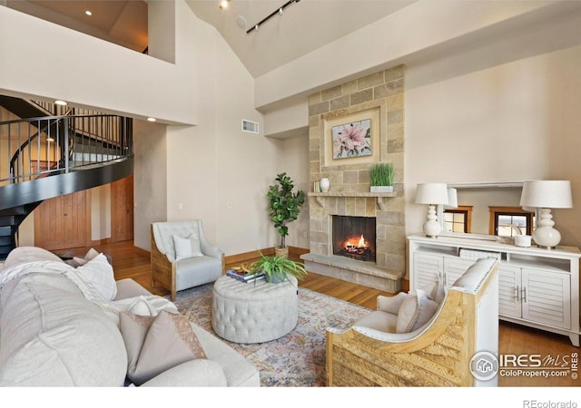 living room with a fireplace, hardwood / wood-style floors, and high vaulted ceiling