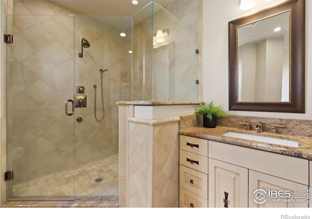 bathroom featuring vanity and a shower with door