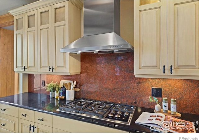 kitchen with cream cabinets, tasteful backsplash, stainless steel gas cooktop, and wall chimney range hood