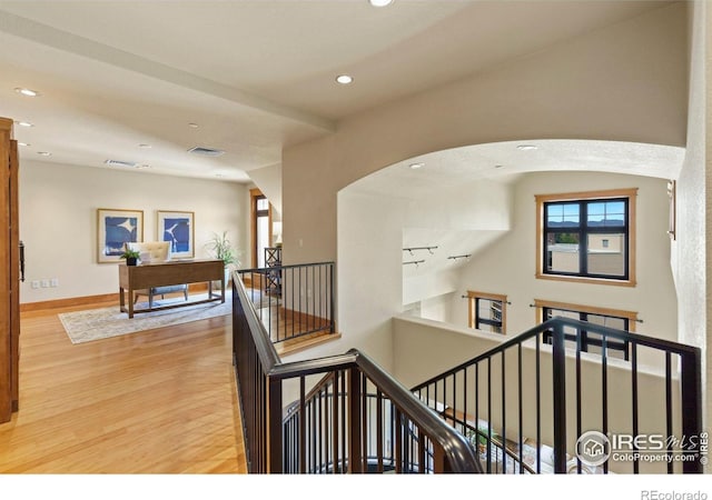 stairway featuring rail lighting and hardwood / wood-style flooring