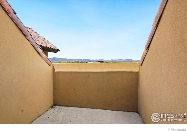 view of patio with a mountain view and a balcony