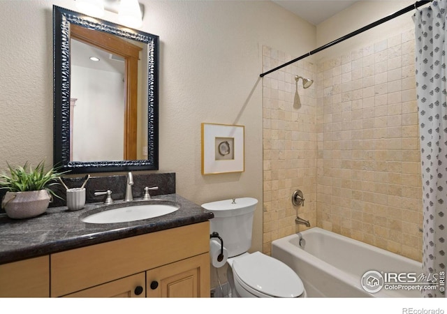 full bathroom with vanity, tiled shower / bath combo, and toilet