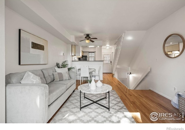 living room featuring ceiling fan and light hardwood / wood-style flooring