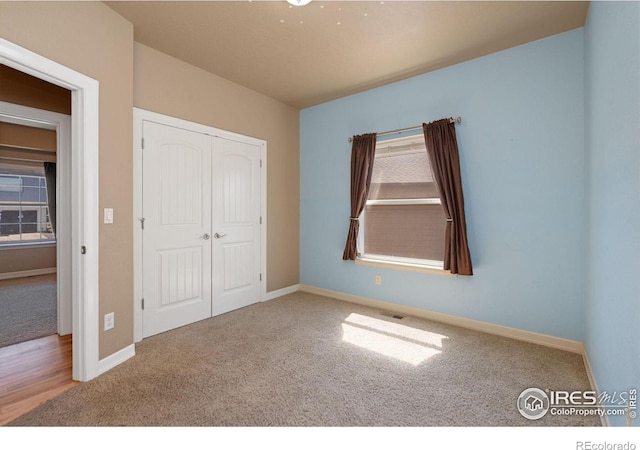 unfurnished bedroom with carpet flooring and a closet