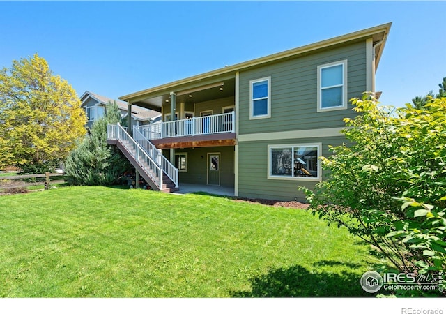 back of house with a deck and a lawn