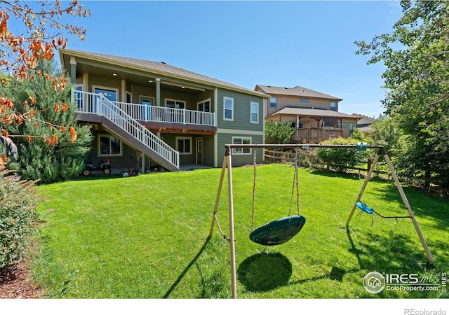 rear view of house with a lawn and a wooden deck